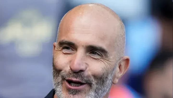 Entrenador sonriendo en un evento deportivo