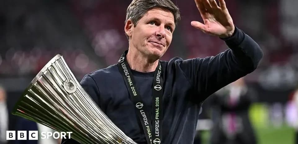 Entrenador sosteniendo trofeo y saludando en celebración