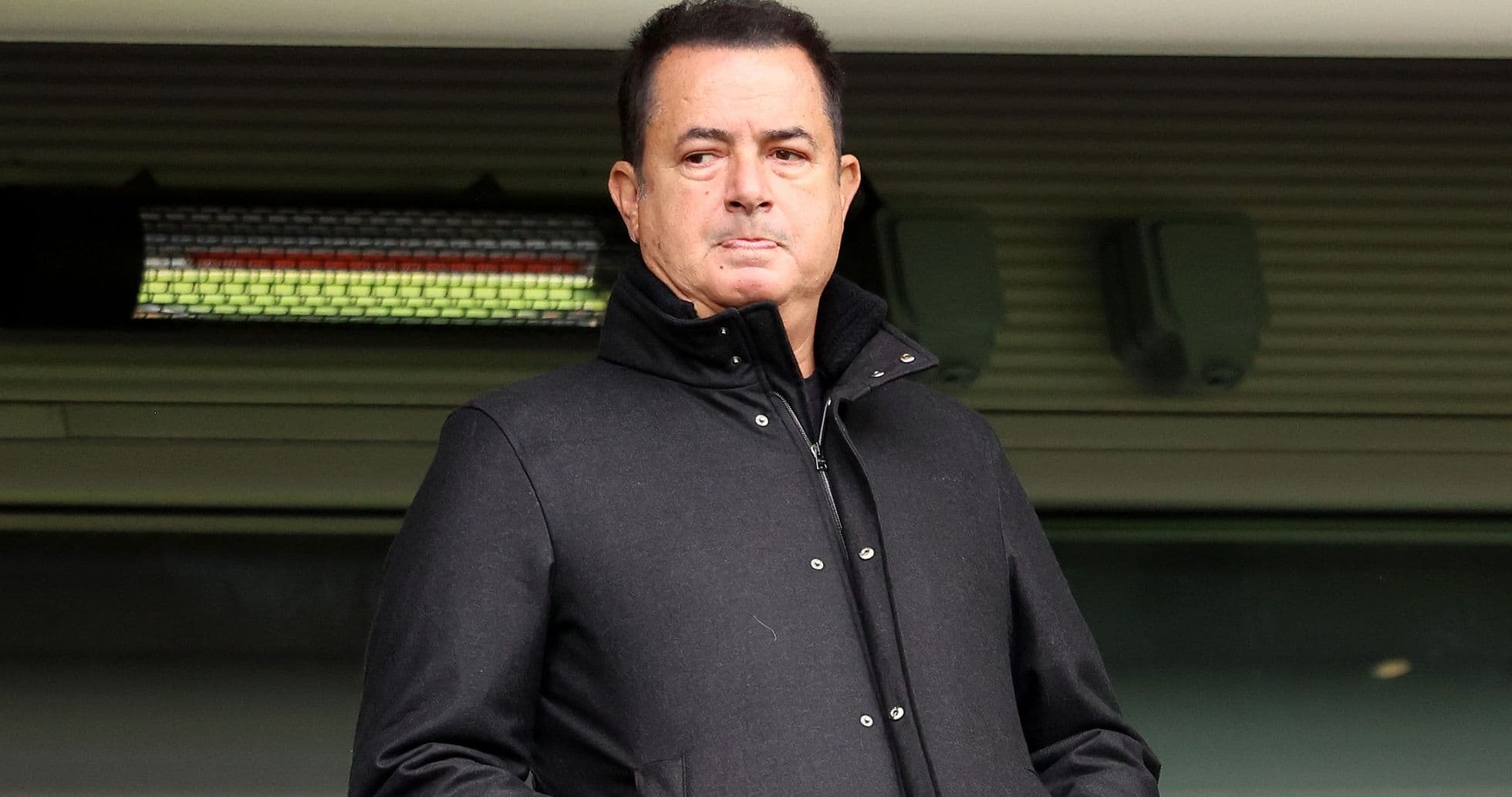 Hombre con abrigo negro en un estadio