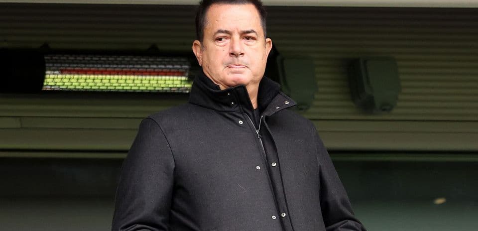 Hombre con abrigo negro en un estadio