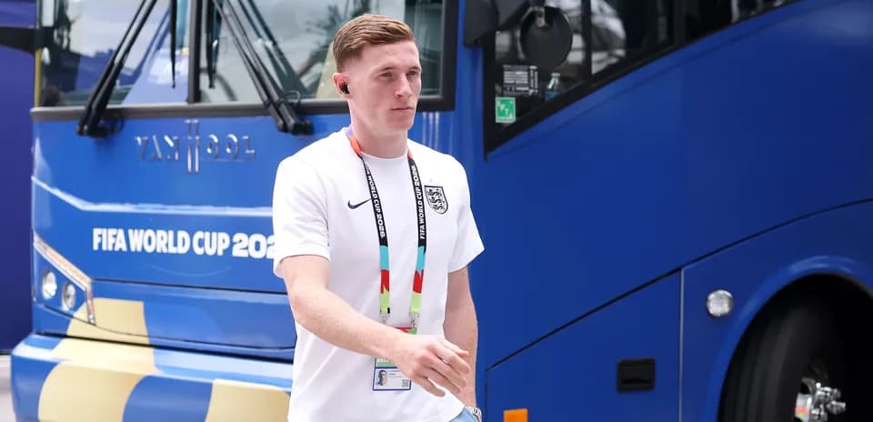 Jugador caminando junto a autobús del Mundial 2026