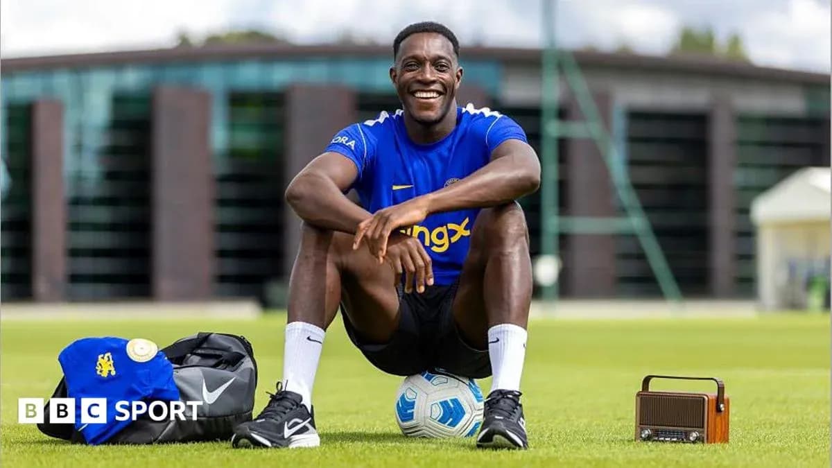 Jugador sentado en el campo con balón y mochila