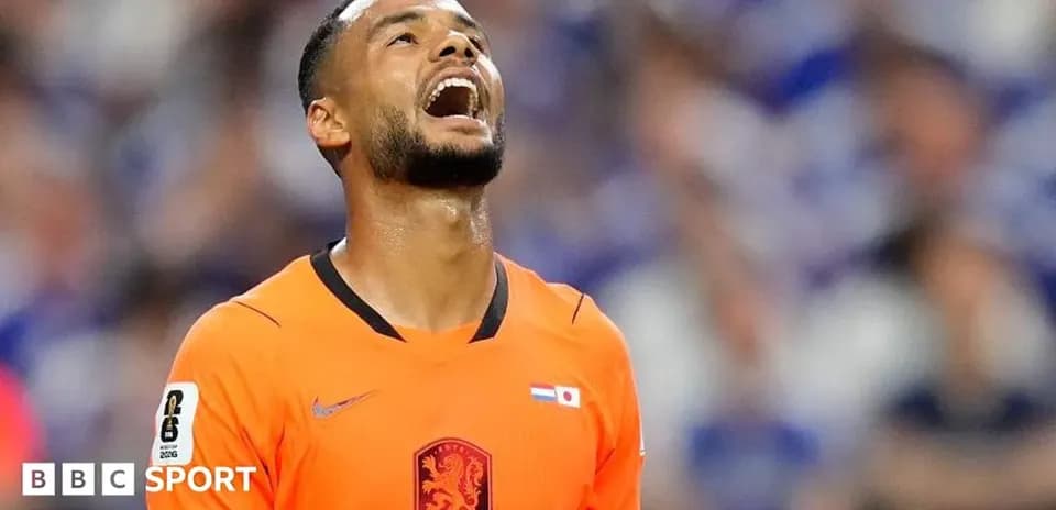 Jugador de fútbol en uniforme naranja mirando al cielo