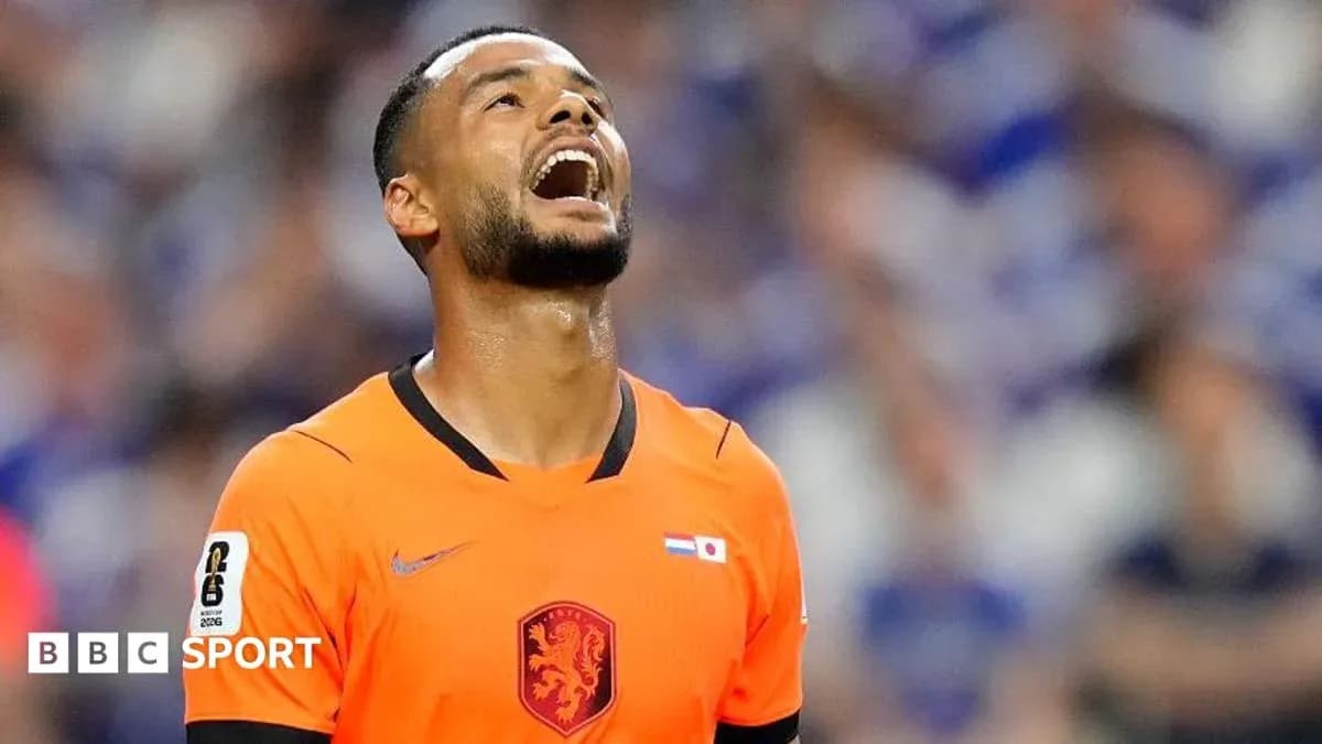 Jugador de fútbol en uniforme naranja mirando al cielo