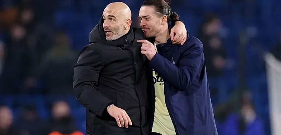 Entrenador y jugador celebrando en el campo