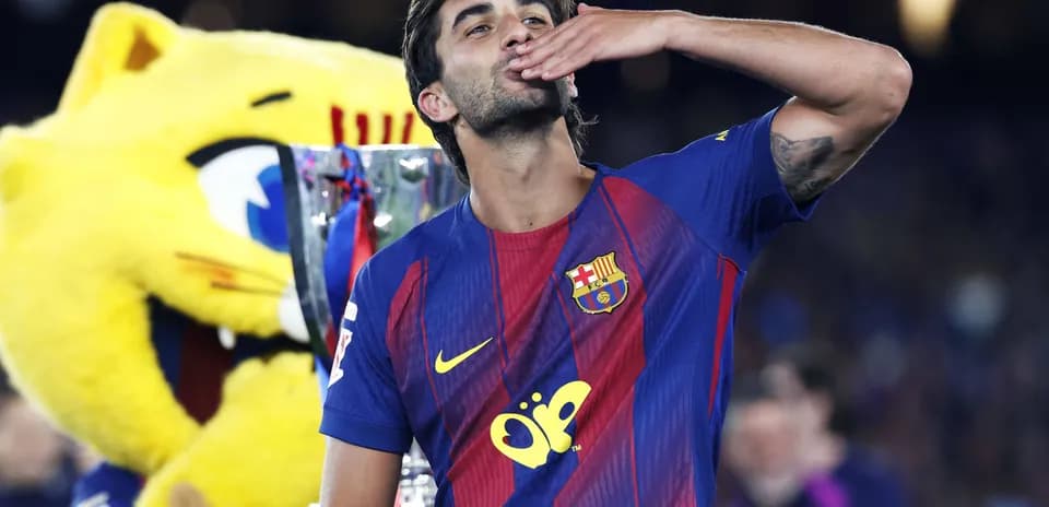 Jugador de Barcelona celebrando con trofeo y mascota