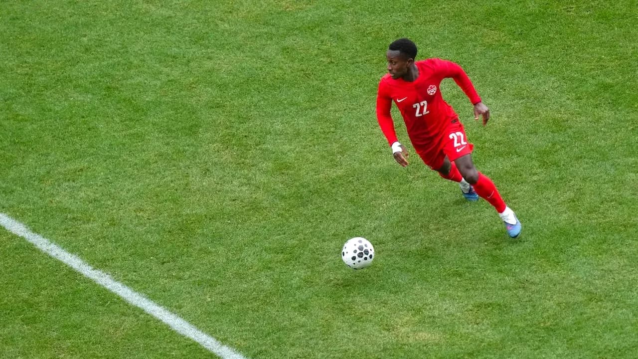 Jugador corriendo con balón en partido de fútbol