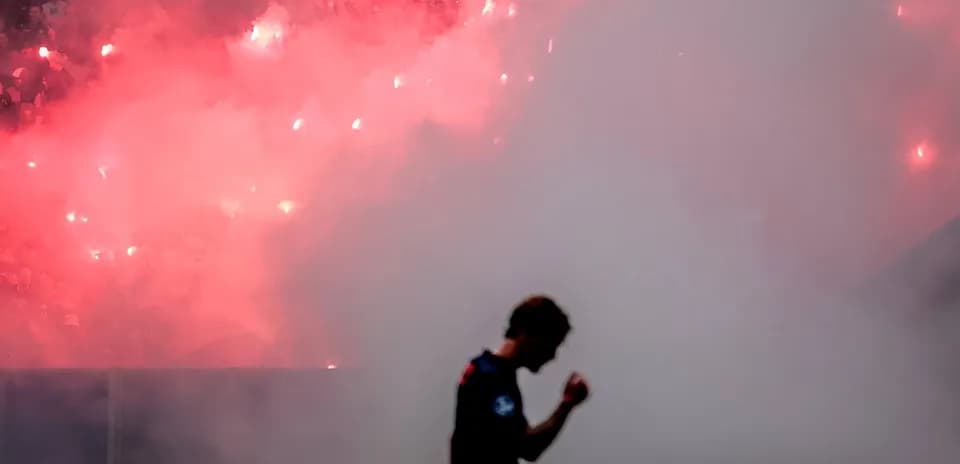 Jugador celebrando con humo y bengalas en el fondo