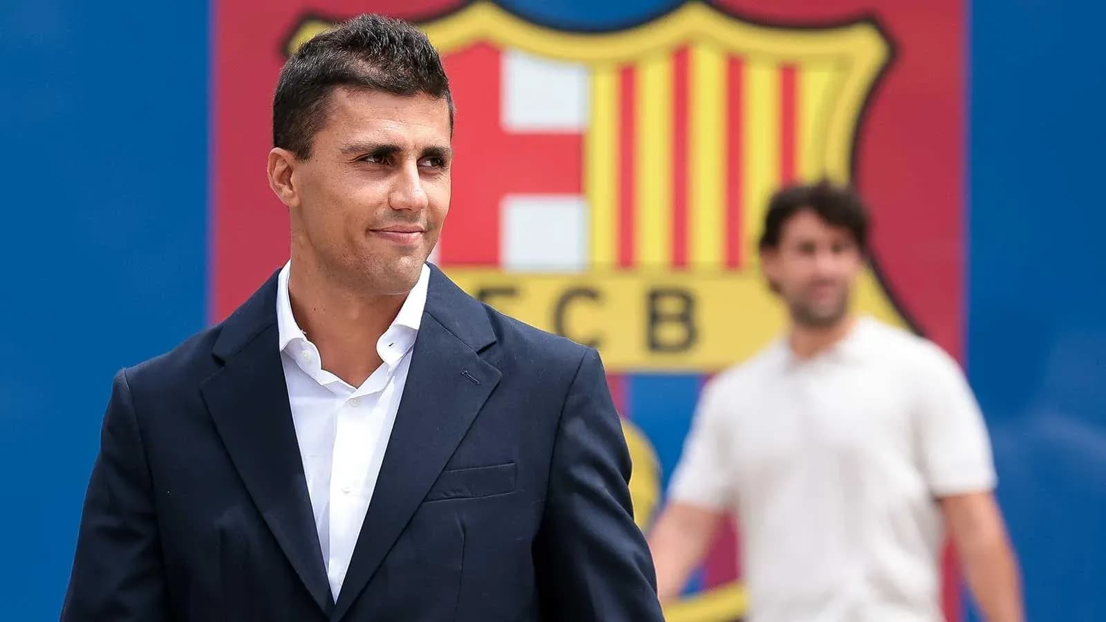 Jugador posando frente al logo del FC Barcelona