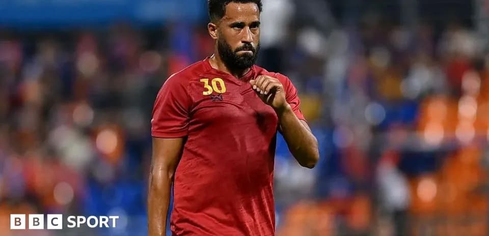 Jugador en camiseta roja caminando por el campo