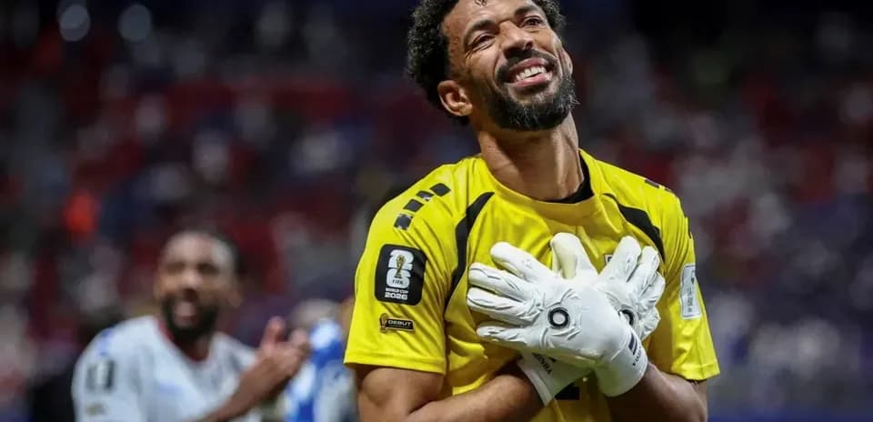 Portero en uniforme celebrando con guantes en mano