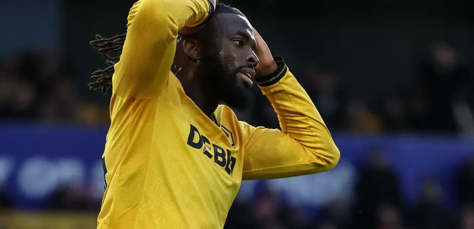Jugador de fútbol con camiseta amarilla lamentando una jugada