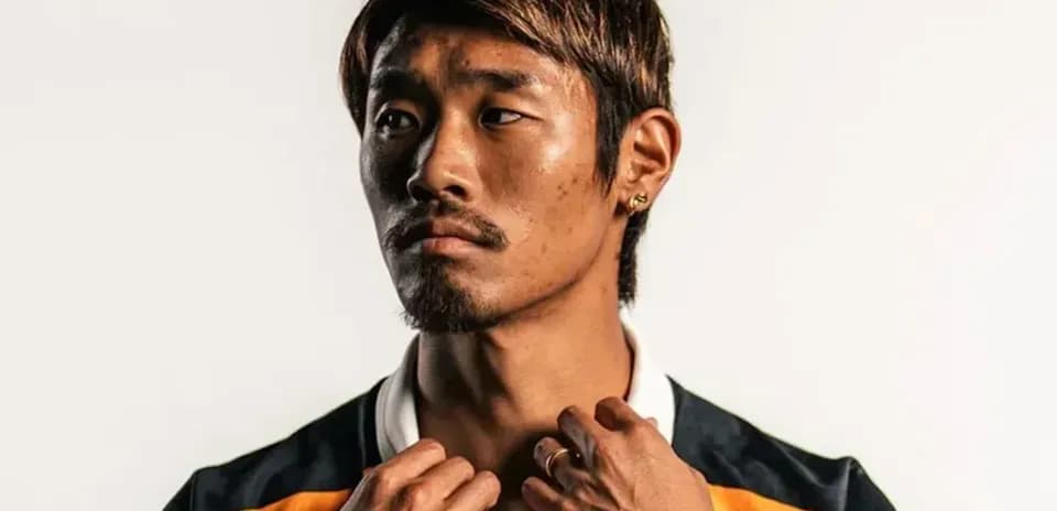 Jugador posando con camiseta de equipo en fondo claro