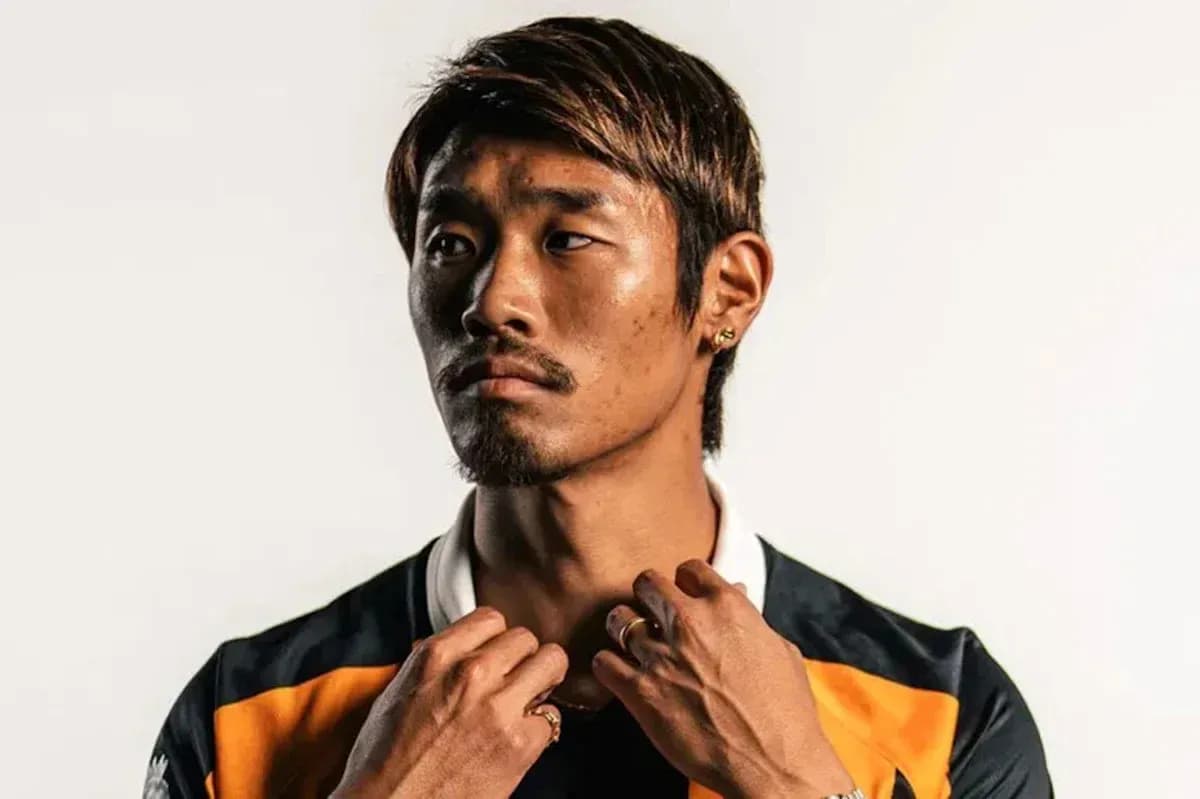 Jugador posando con camiseta de equipo en fondo claro