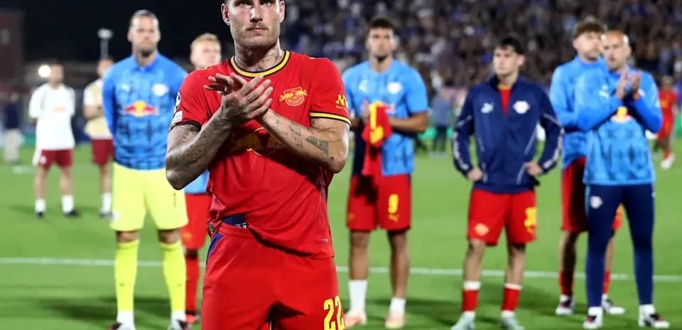 Jugador aplaudiendo con compañeros al fondo