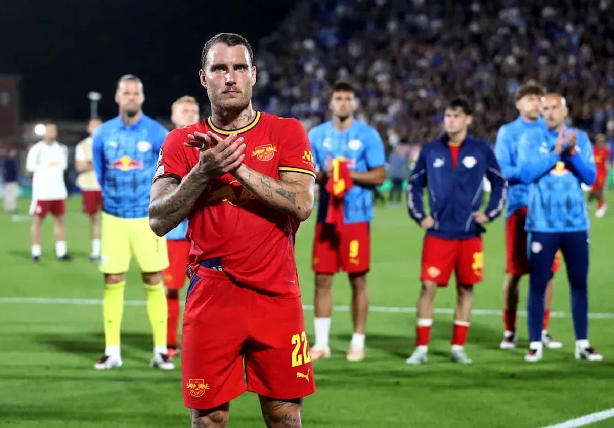 Jugador aplaudiendo con compañeros al fondo