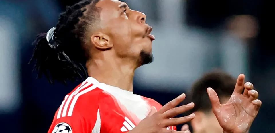 Jugador de fútbol con camiseta roja mirando hacia arriba