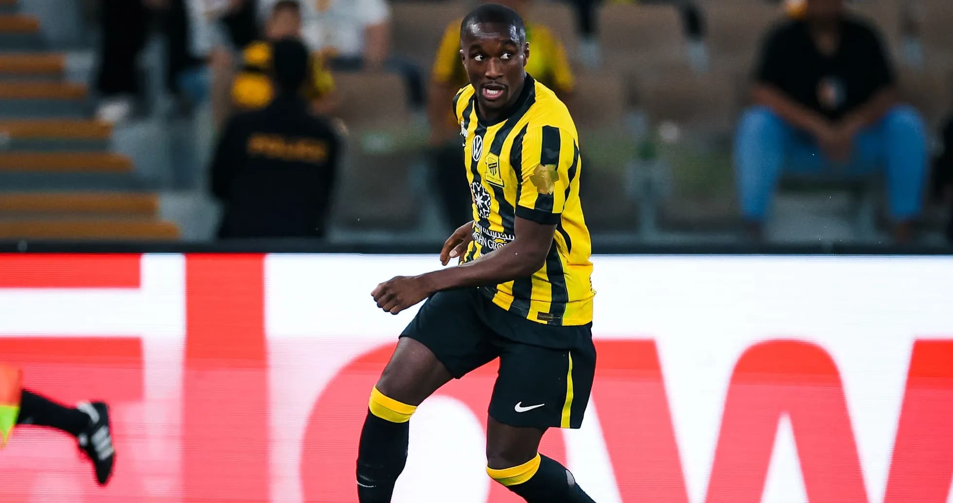 Jugador de fútbol corriendo en campo con uniforme amarillo