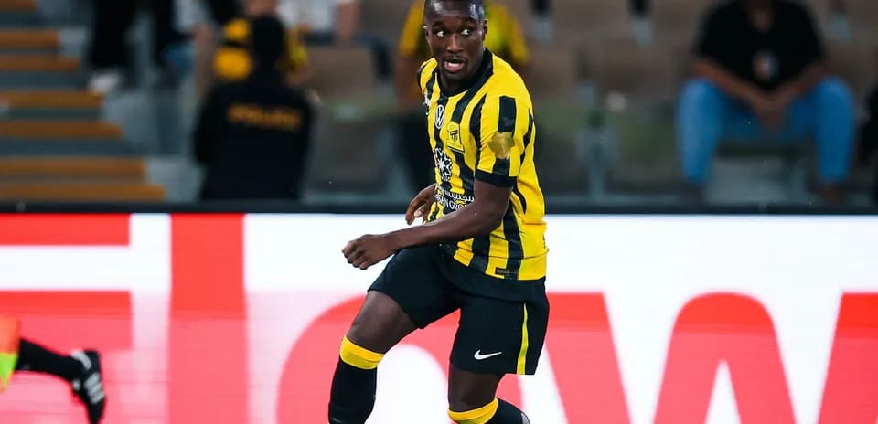 Jugador de fútbol corriendo en campo con uniforme amarillo