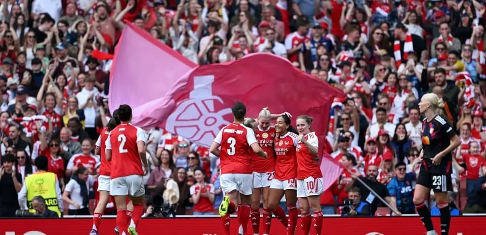 Jugadoras de Arsenal celebrando un gol con aficionados