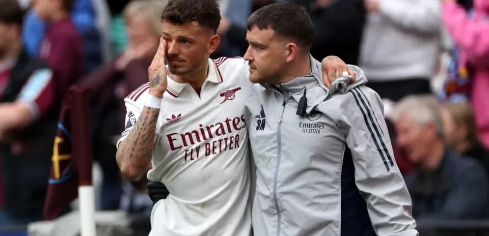 Jugador de Arsenal acompañado por un miembro del staff