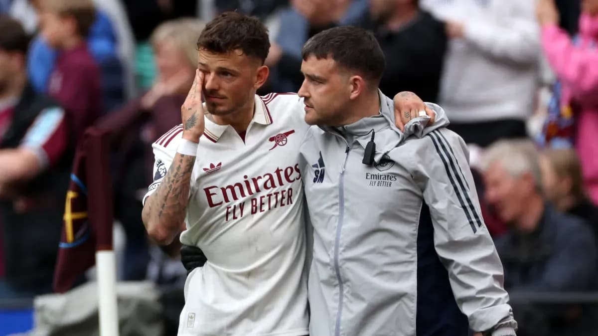 Jugador de Arsenal acompañado por un miembro del staff
