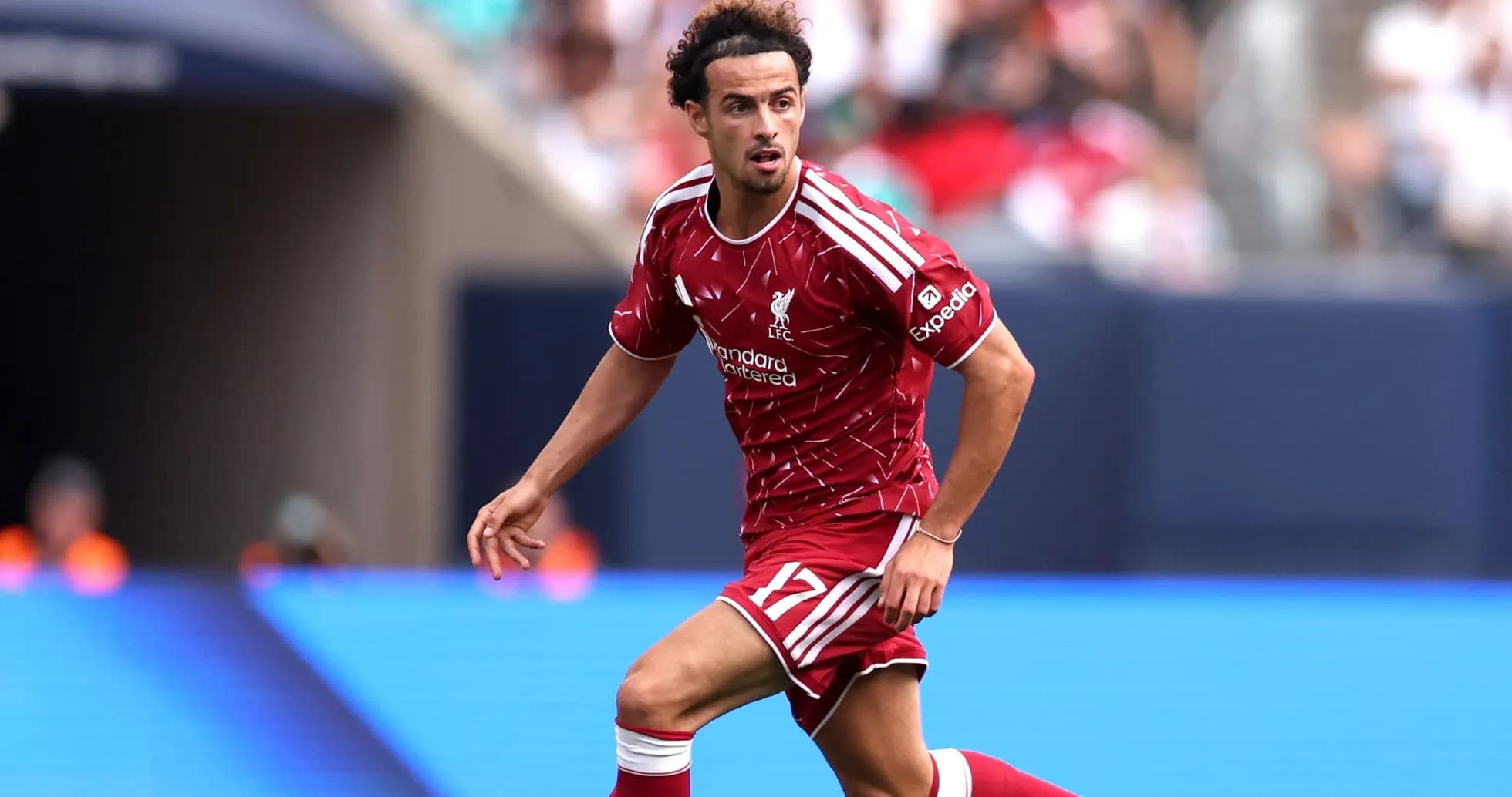 Jugador de Liverpool corriendo con el balón en el campo
