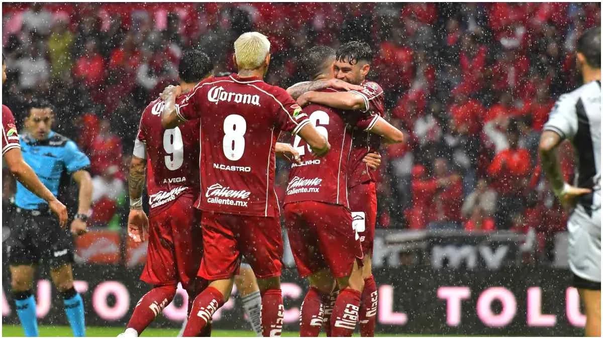 Jugadores de Toluca celebrando un gol bajo la lluvia