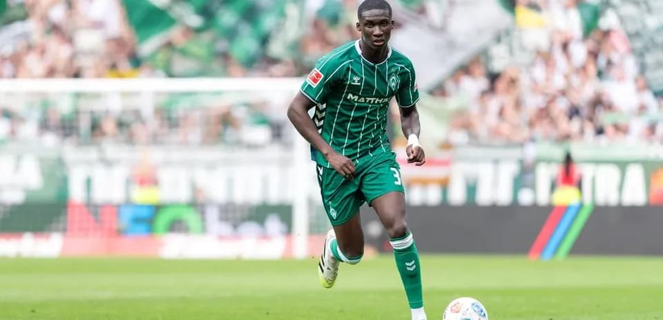 Jugador corriendo con balón en el campo de juego