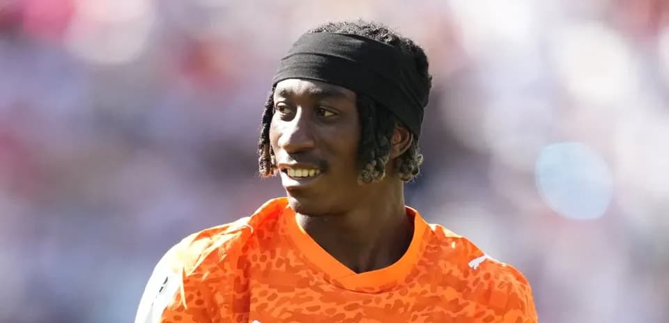 Jugador con camiseta naranja en el campo de fútbol