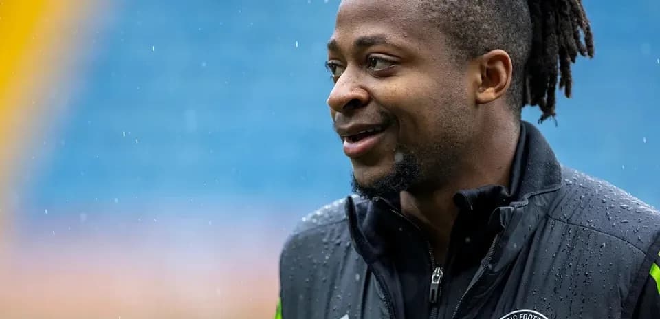 Jugador sonriente con chaqueta de entrenamiento en el campo