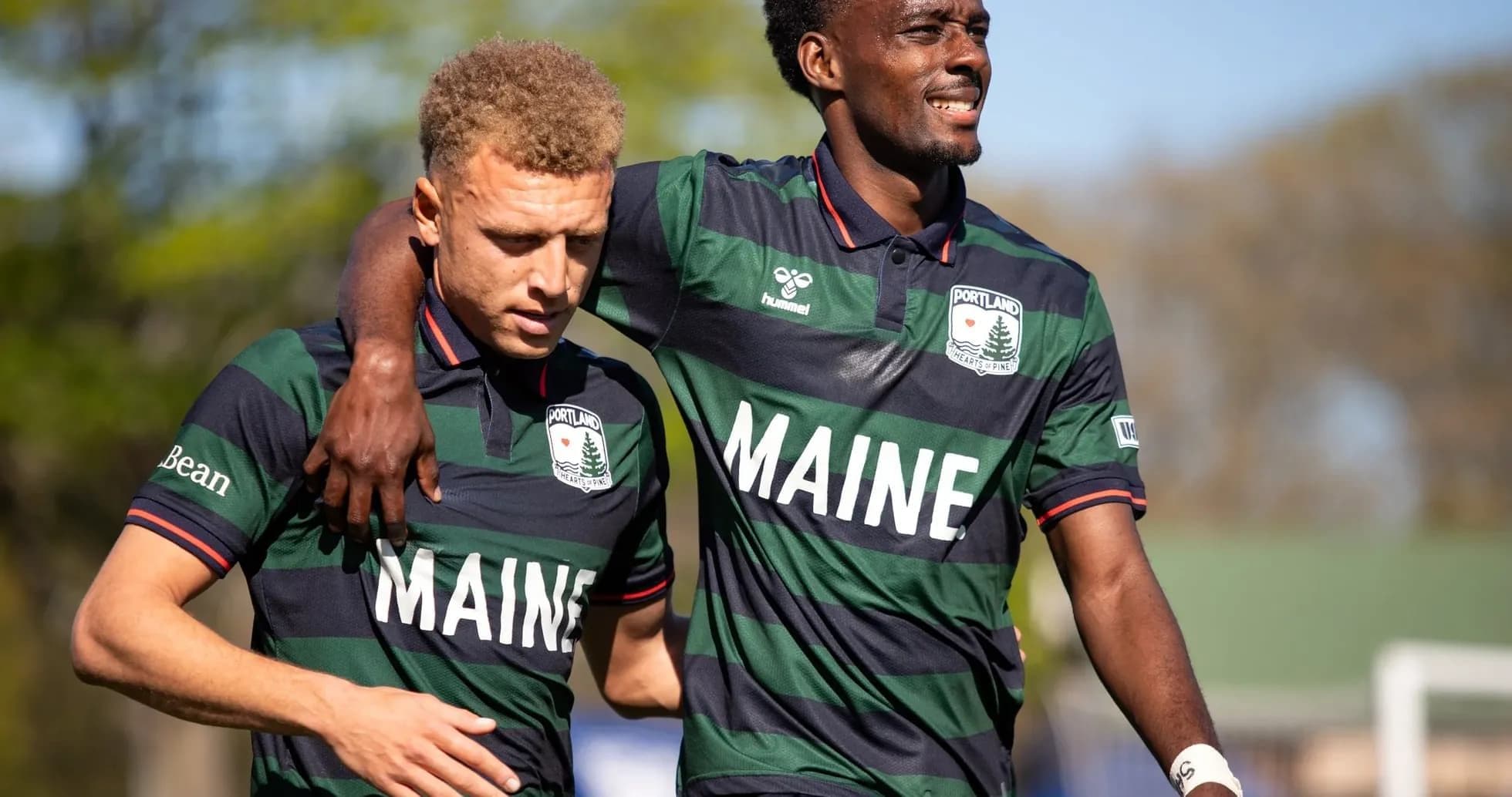 Dos jugadores del Portland Hearts of Pine abrazados