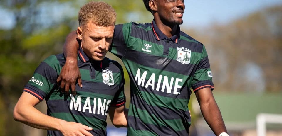 Dos jugadores del Portland Hearts of Pine abrazados