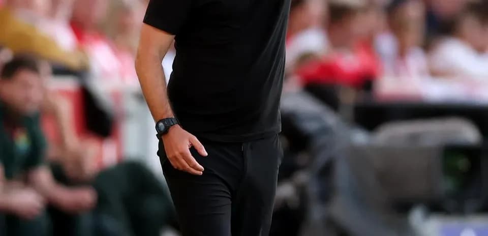Entrenador dirigiendo a su equipo desde la línea de banda