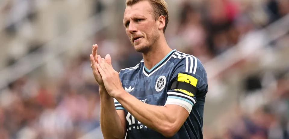 Jugador aplaudiendo con camiseta de su equipo