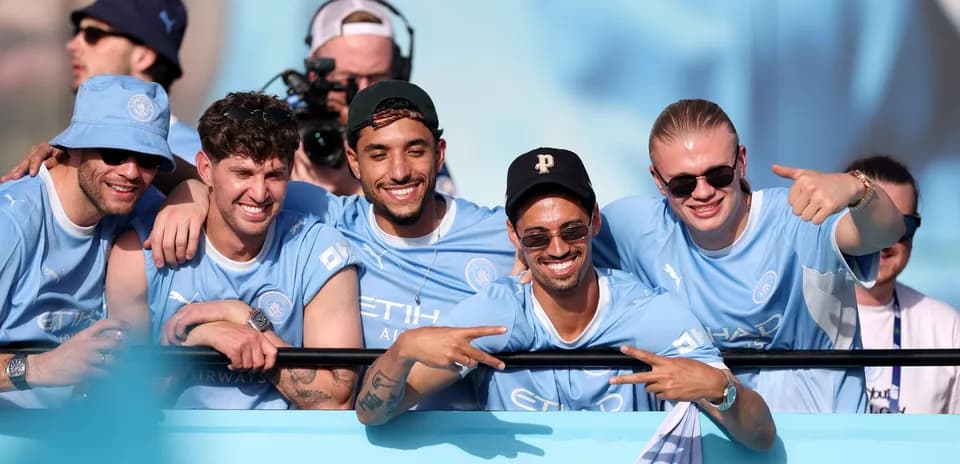 Cinco aficionados de Manchester City celebrando juntos