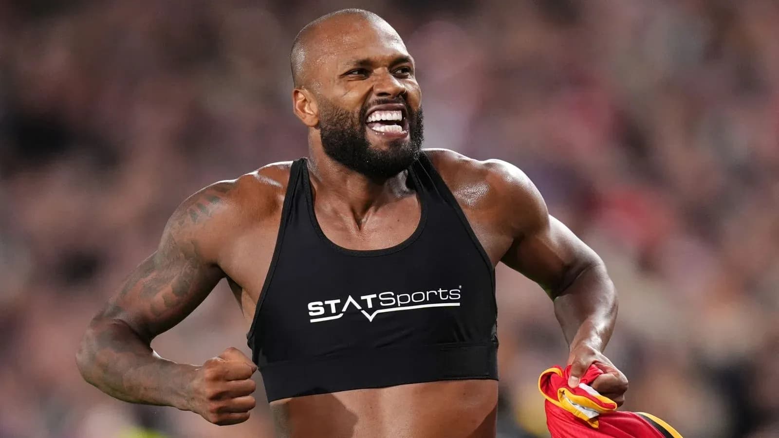 Atleta celebrando con camiseta en mano durante competición