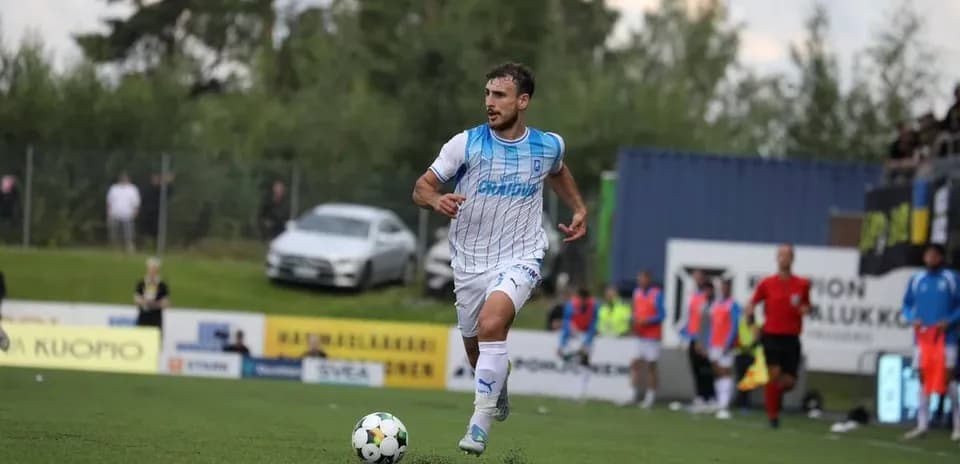Jugador corriendo con el balón en el campo