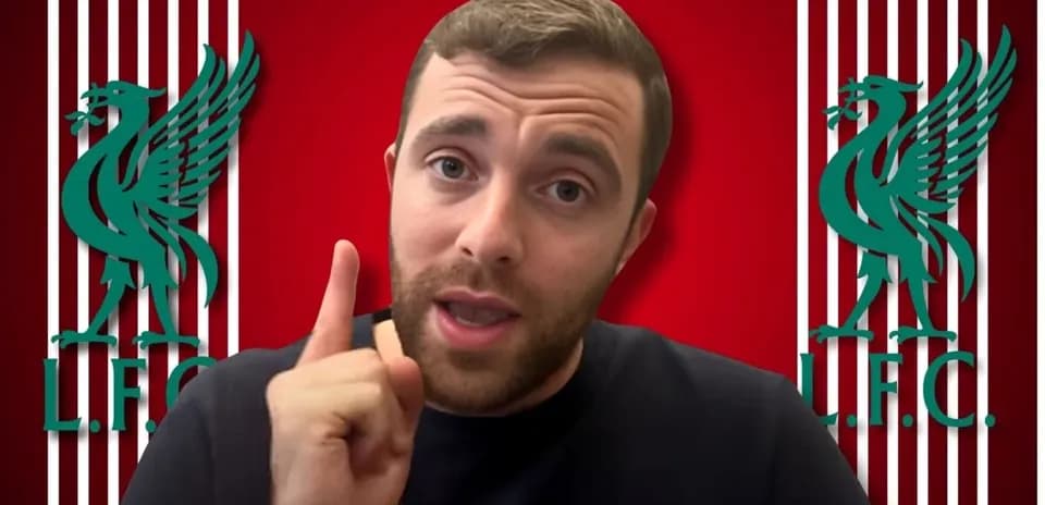 Hombre hablando con fondo de escudo del Liverpool