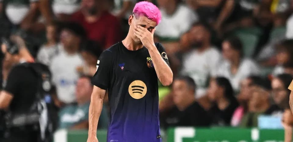 Jugador con cabello rosa se lamenta en el campo