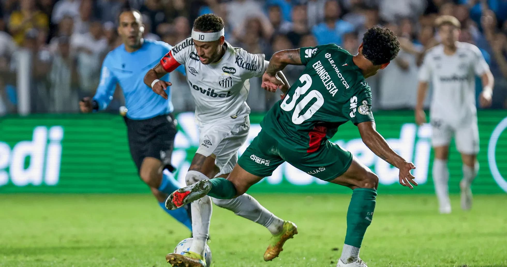 Jugador de Santos driblando a defensor durante partido