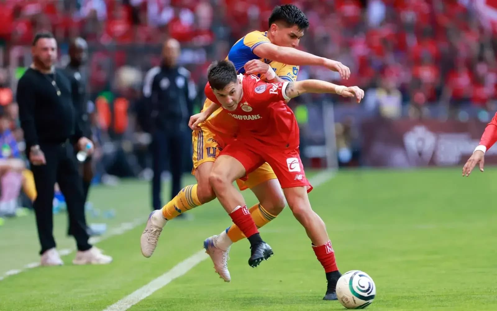 Jugadores de Toluca y Tigres UANL en acción