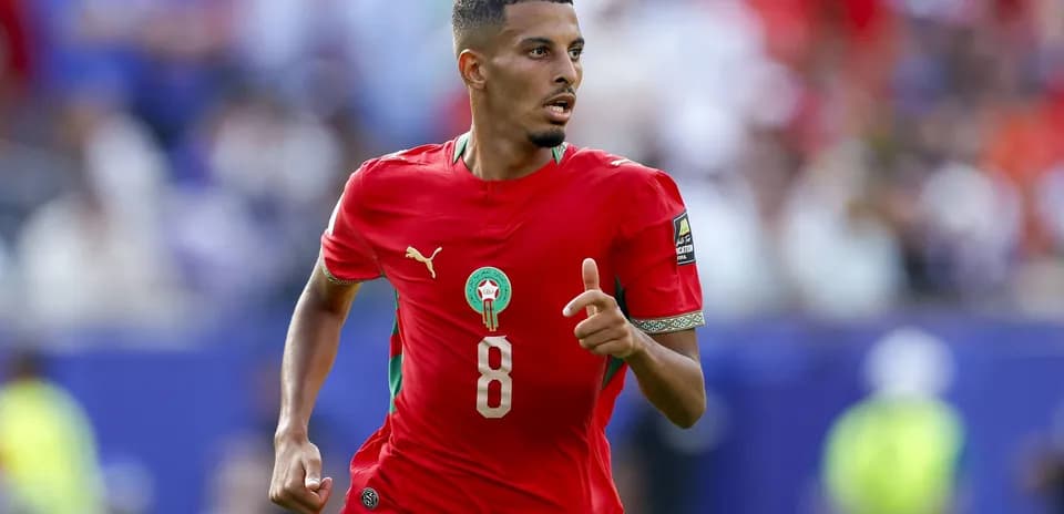 Jugador de Marruecos corriendo con balón en el campo
