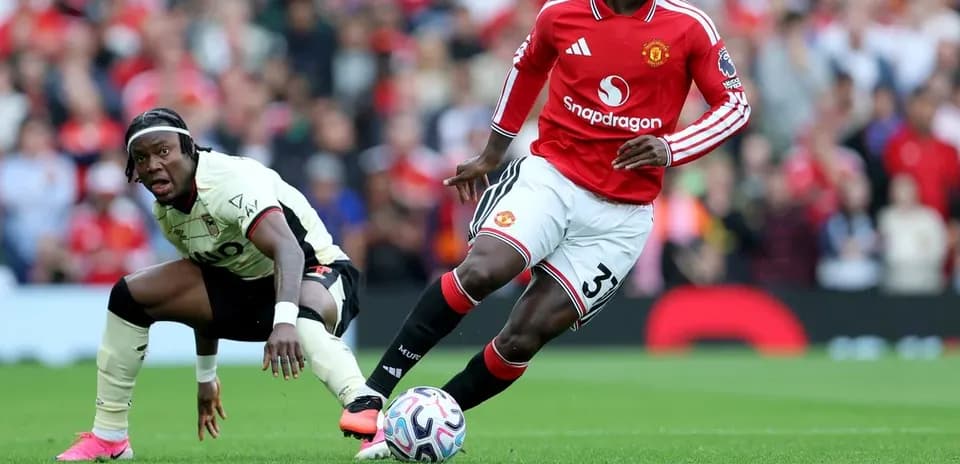 Jugador de Manchester United driblando balón en el campo