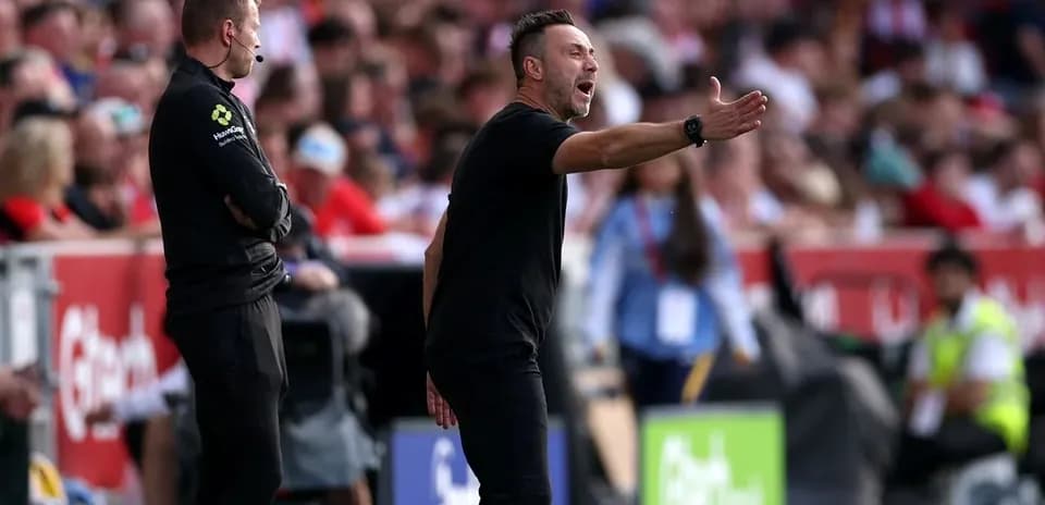 Entrenador dando instrucciones desde la línea de banda