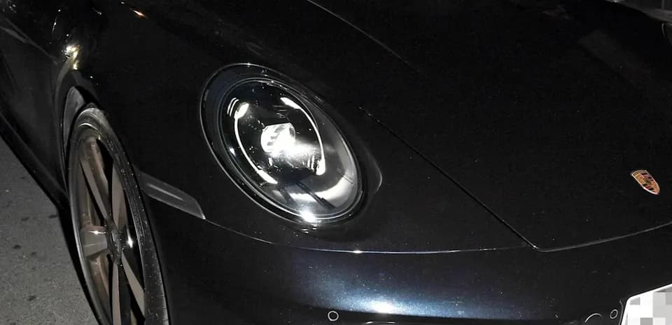 Dos hombres en un coche deportivo Porsche en la noche