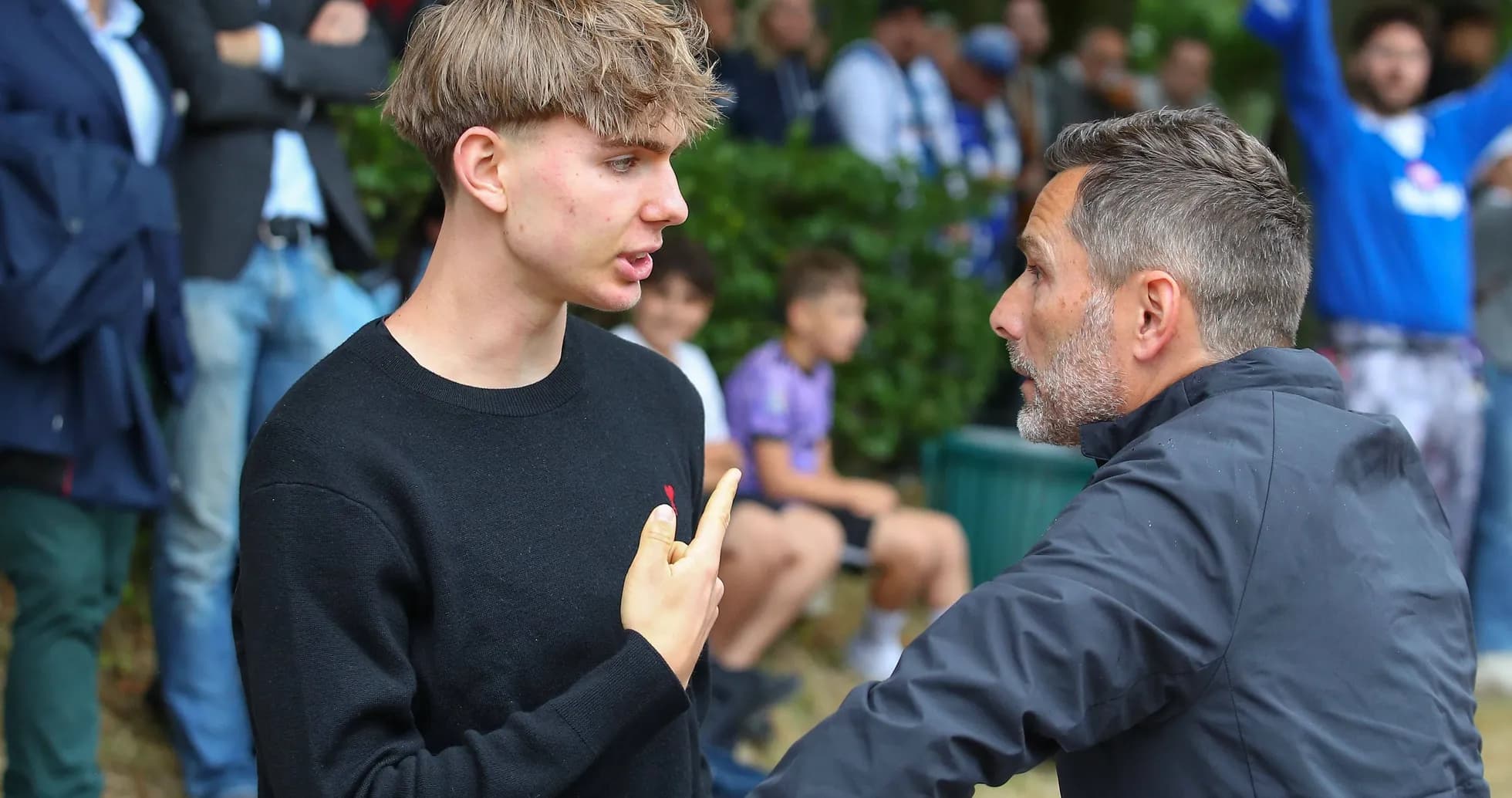 Joven conversando con un entrenador en el partido