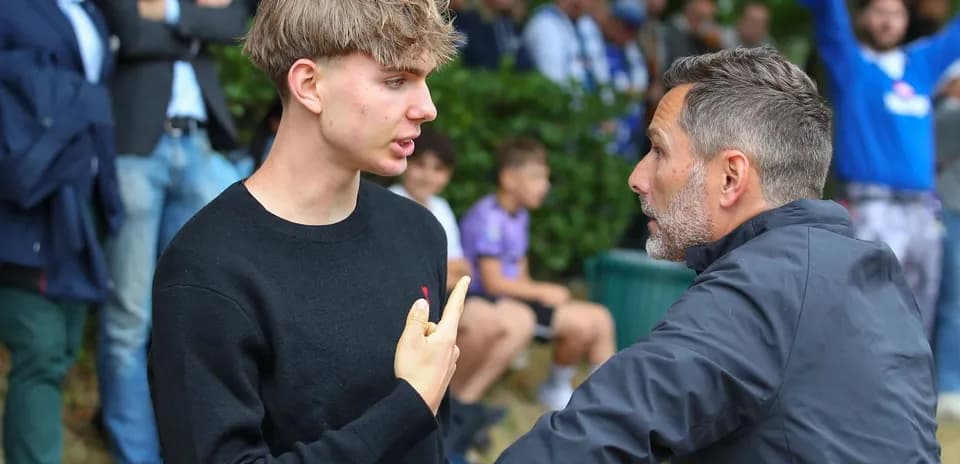 Joven conversando con un entrenador en el partido