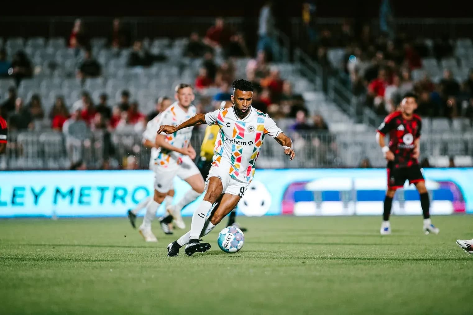 Jugador corriendo con el balón en el partido