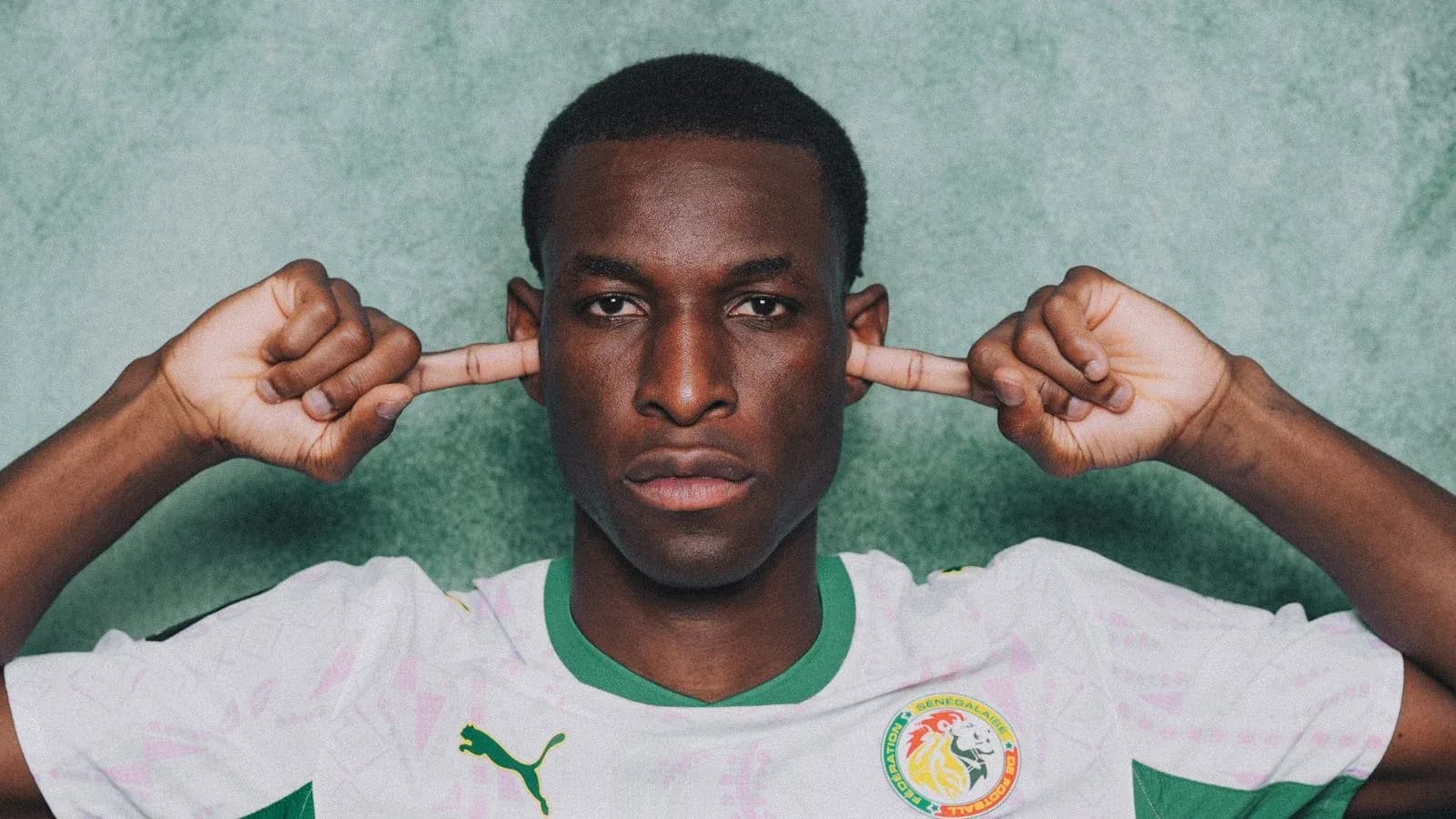 Jugador de fútbol cubriendo sus oídos con las manos